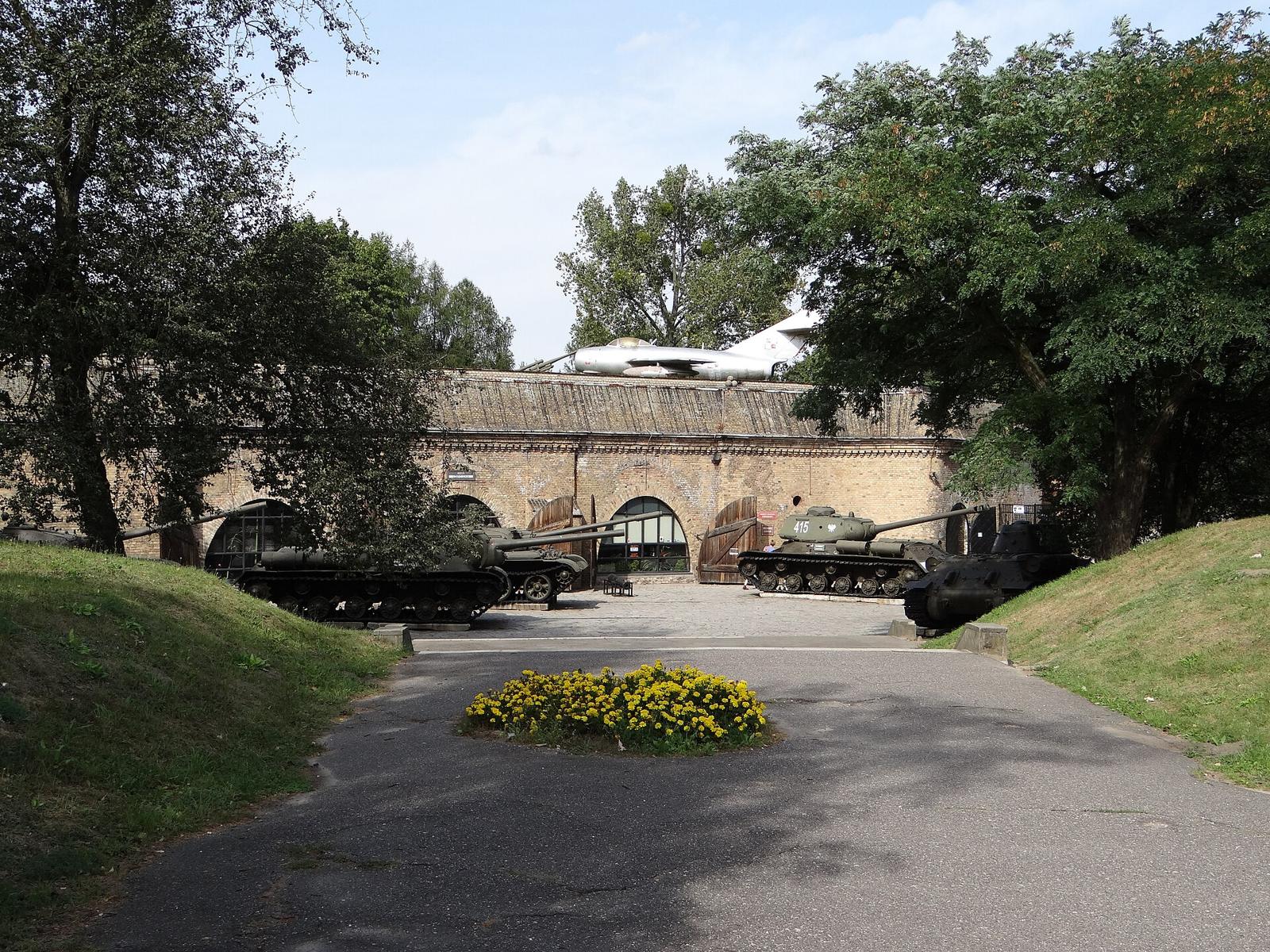 The entrance to the Armament Museum in Cytadela Park, with tanks and an aeroplane in front of the gate